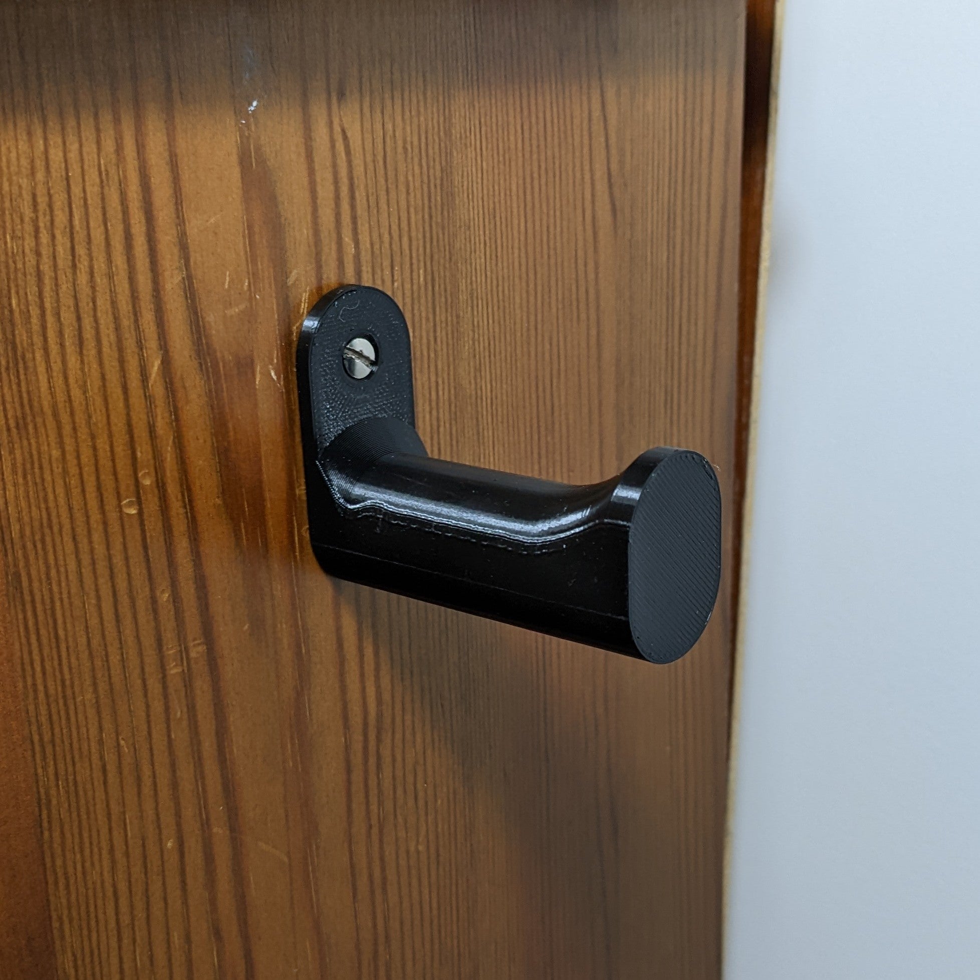 Seinään asennettava kuulokepidike – kompakti muotoilu