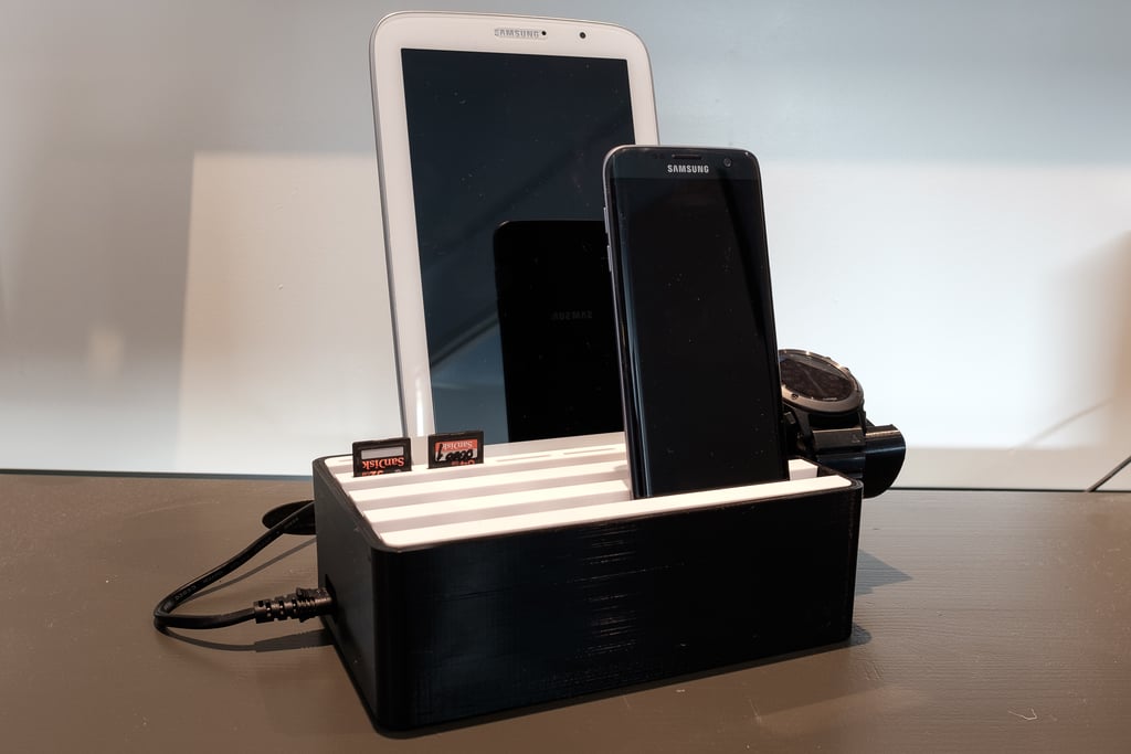 Tabletti, puhelin, älykello, SD-korttipidike ja USB-laturi
