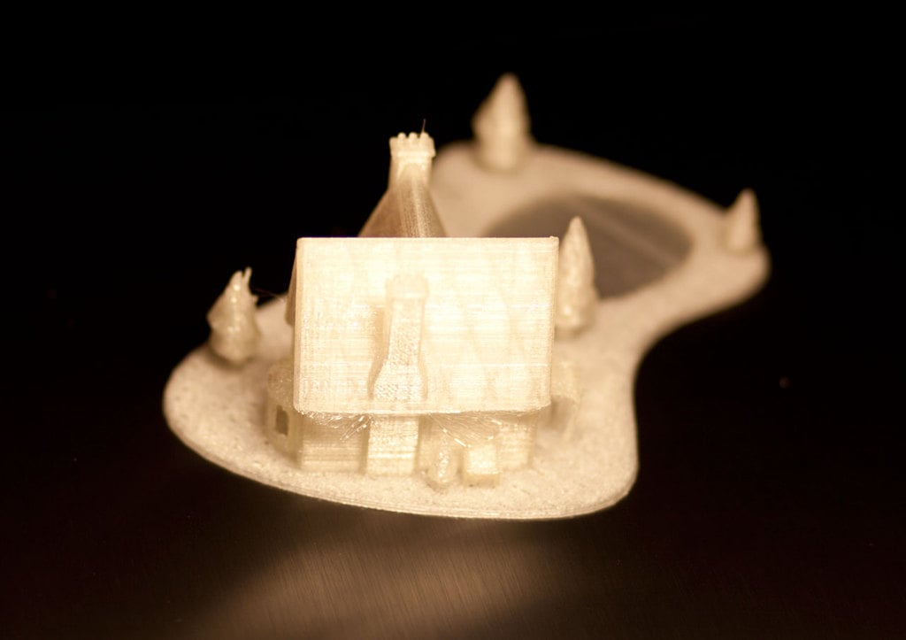 3D-tulostettu joulutalo, jossa on jäätynyt järvi
