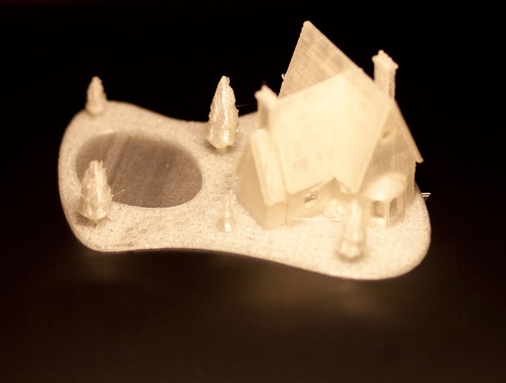 3D-tulostettu joulutalo, jossa on jäätynyt järvi