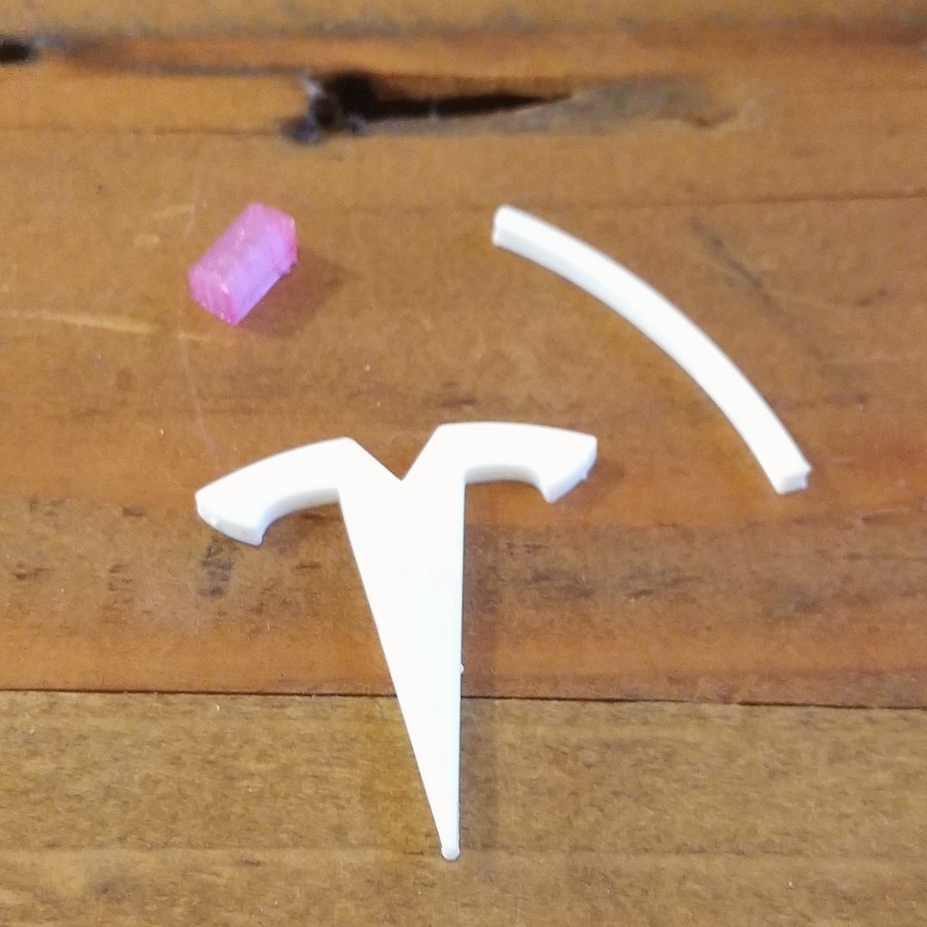 Tesla Charger Organizer erillisellä logosisäkkeellä ja nupilla